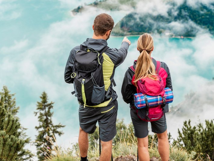 Zwei Wanderer blicken vom Herzogstand ins Tal., &copy; shutterstock_1872412318