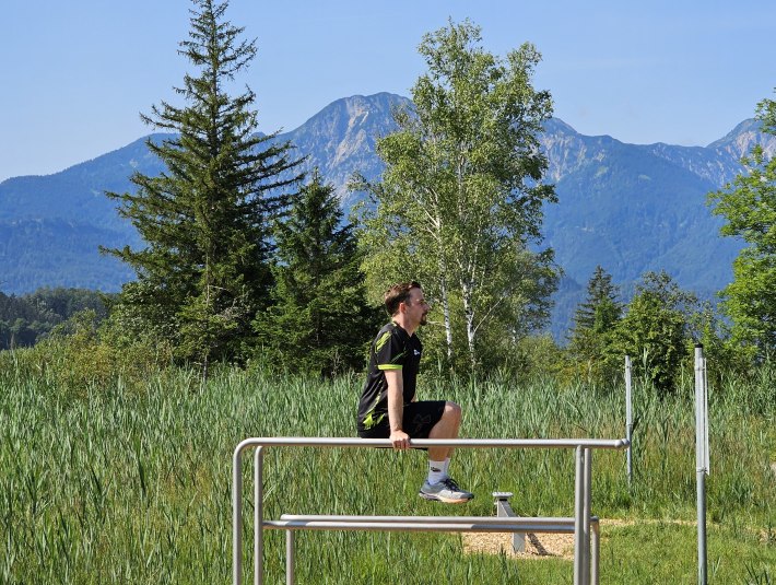 Der Personal Fitness Trainer macht eine &Uuml;bung im Outdoor Bewegungsparcours in Kochel a. See, &copy; Tourist Information Kochel a. See, Fotograf: D. Weickel