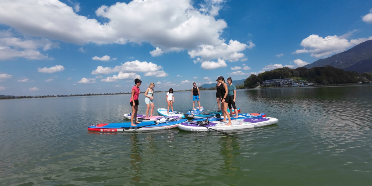 Teilnehmer machen eine Yoga- &Uuml;bung auf dem SUP auf dem Kochelsee, &copy; Roxana, Yogaroxy
