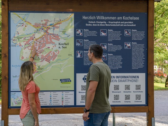 Zwei Personen schauen sich den Ortsplan von Kochel a. See an., © Torusit Information Kochel a. See; Fotograf B. Ritschel