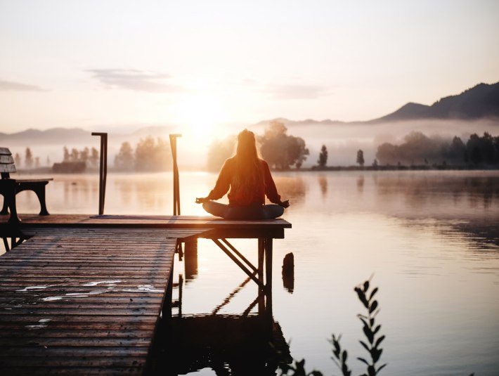 Eine Frau medititert im Schneidersitz am Kochelsee., &copy; Anna Sch&ouml;l&szlig;